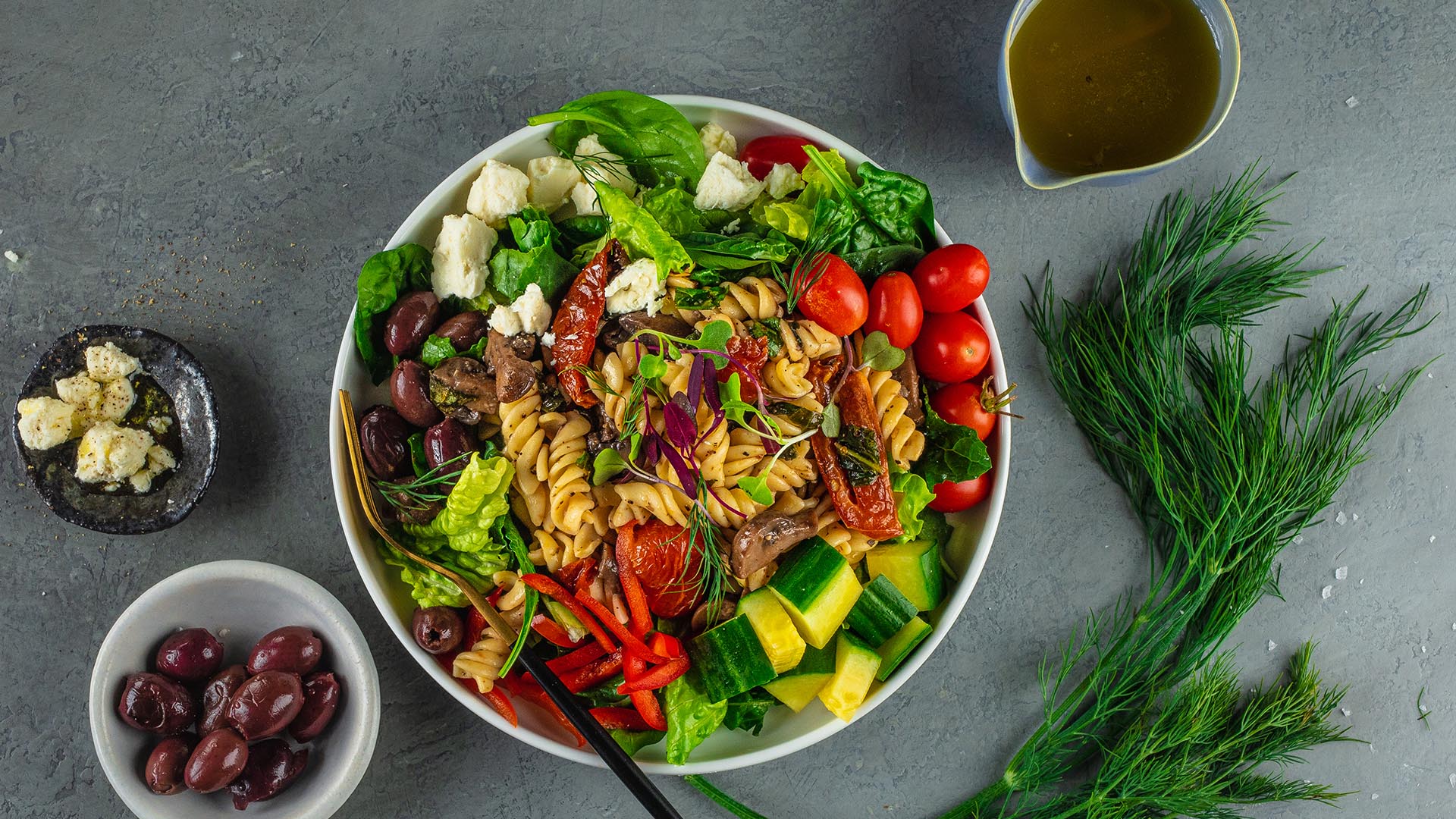 greek salad with pasta in bowl